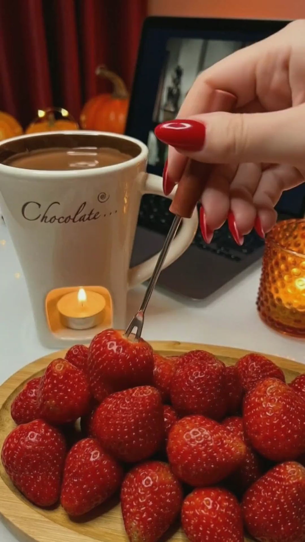 Fresas mojadas en chocolate fundido en la taza fondue