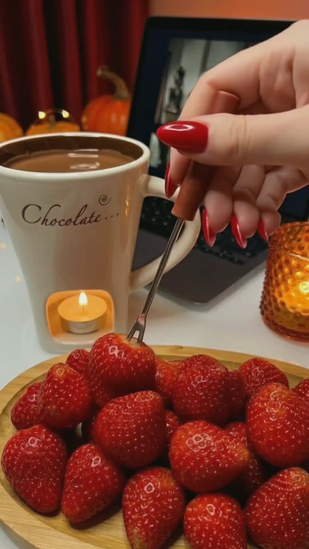 Fresas mojadas en chocolate fundido en la taza fondue
